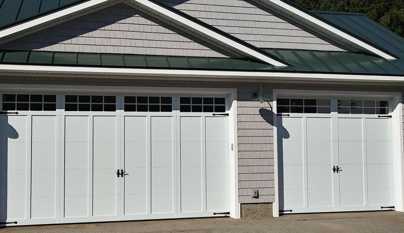 Two garage doors positioned beneath a green roof, showcasing a harmonious blend of architecture and nature.