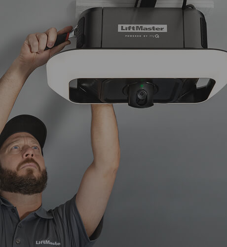 Technician installing a LiftMaster garage door opener in a residential garage in Lewiston, Maine
